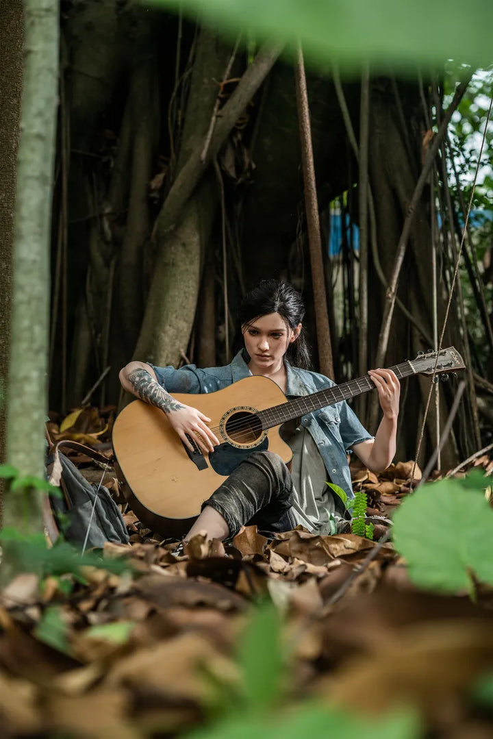 Frau spielt Gitarre im Wald