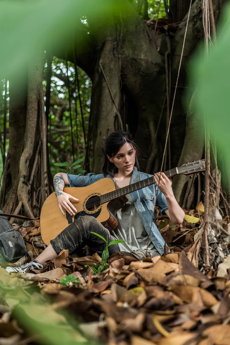 Frau spielt Gitarre im Wald